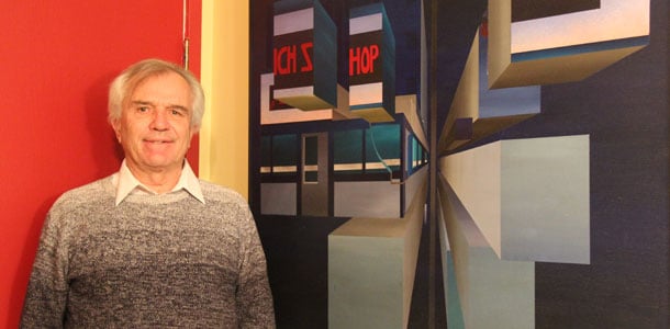 Yann Herry se tient devant la peinture de Raymond Breton de l’ancien café No Pop Shop, témoin des discussions ayant mené à la naissance de l’Association franco-yukonaise en 1982. — Kelly Tabuteau - L'Aurore boréale