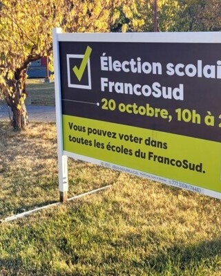 À l'École Sainte-Marguerite-Bourgeoys, comme dans toutes les autres écoles de la province, les portes sont closes et seul un panneau annonçant les prochaines élections semble rappeler la vie scolaire.  — Photo : Arnaud Barbet