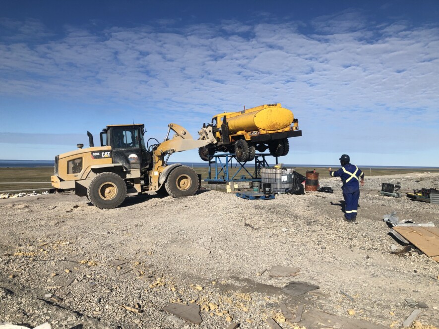 À Ulukhaktok en juillet 2023, le personnel de KBL Environmental s’affaire à retirer de la décharge un camion-citerne.  — Courtoisie MAMC