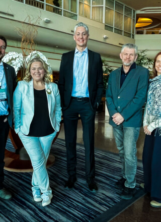 Au Roundup de Vancouver, le député Julian Morse et les ministres Caitlin Cleveland, Jay McDonald et Caroline Wawzonek entourent le premier ministre des TNO, RJ Simpson. &mdash; Courtoisie