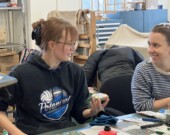 Un petit groupe de personnes apprend à confectionner des œuvres d’art avec des fragments de tuiles. &mdash; Photo Élodie Roy