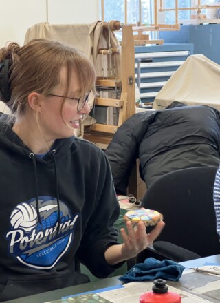 Un petit groupe de personnes apprend à confectionner des œuvres d’art avec des fragments de tuiles. &mdash; Photo Élodie Roy