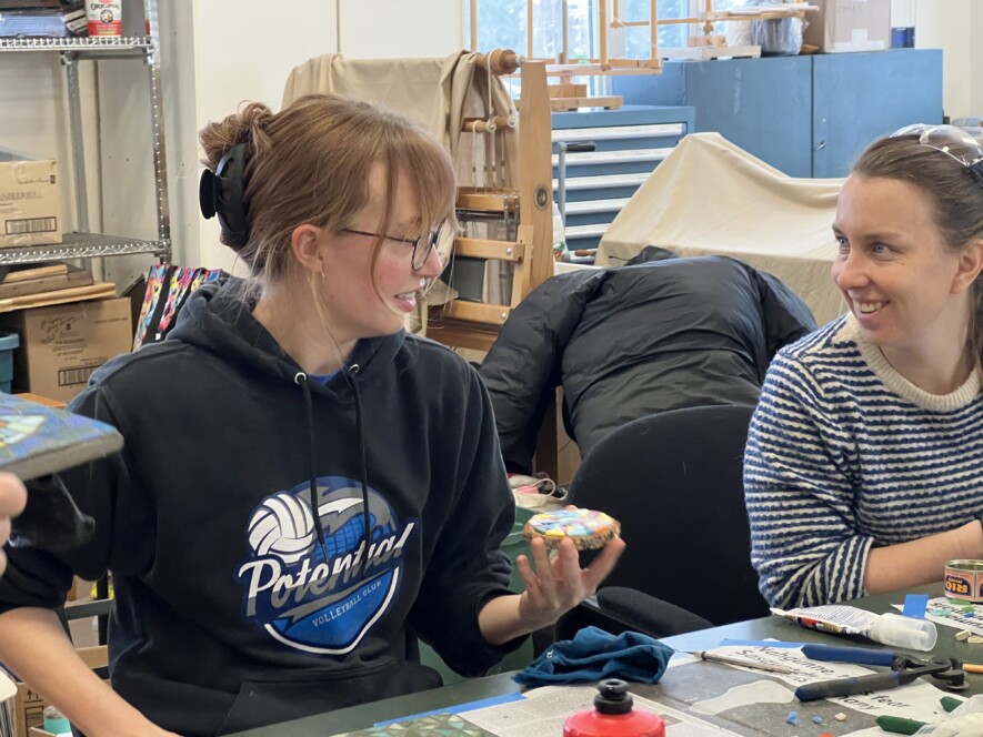 Un petit groupe de personnes apprend à confectionner des œuvres d’art avec des fragments de tuiles. &mdash; Photo Élodie Roy