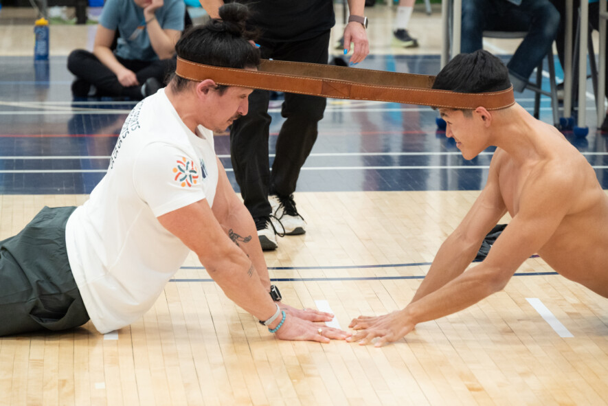 Allongés face à face, le ventre au sol et la tête à égale distance d’une ligne de démarcation perpendiculaire à la direction de leur corps, deux athlètes adverses ont une ceinture en cuir bouclée placée autour de leur tête, au-dessus des oreilles. Ensuite, ils se redressent jusqu’à ce que seuls leurs mains, leurs pieds et leurs genoux touchent le sol. Enfin, chaque athlète essaie de tirer son adversaire vers l’avant afin que ses mains se trouvent à deux pieds au-delà de la ligne de démarcation, ou afin que la tête de l’adversaire tombe et lâche la ceinture. Il n’y a qu’une seule traction par match. &mdash; Photo Nelly Guidici