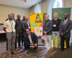 À gauche, Charlie Mballa avec des participants de l’Institut d’été entourant la bannière du GRAAL. Photo : Courtoisie  