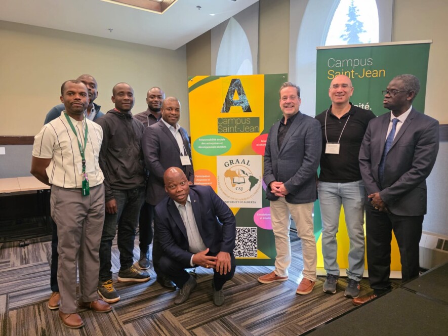 À gauche, Charlie Mballa avec des participants de l’Institut d’été entourant la bannière du GRAAL. Photo : Courtoisie  