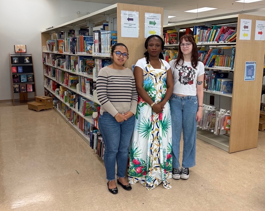 Les bibliothèques francophones, comme celle de l’Institut Guy-Lacombe de la famille, ne sont pas nombreuses, mais très utiles pour la communauté francophone. Ici, Nina Natacha Raharimiadana, Mélanie (aide-bibliothécaire) et Alexie (aide-bibliothécaire). Photo : Courtoisie  