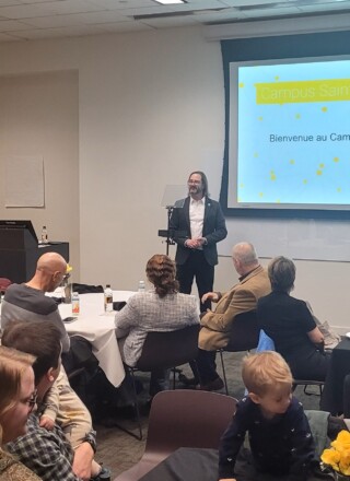 Jason Carey, doyen du Campus Saint-Jean, lors de sa présentation au brunch communautaire du Campus Saint-Jean qui a eu lieu à son campus satellite de Calgary. Photo : Arnaud Barbet
  