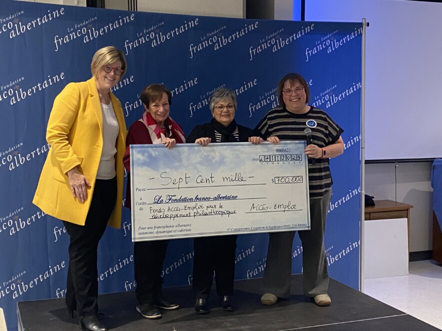 Des membres d'Accès Emploi remettent un chèque de 700 000$ à la vice-présidente de La Fondation franco-albertaine pour soutenir le développement philanthropique. C'est le plus important don jamais fait à la fondation communautaire francophone. Photo : Titti Freeman