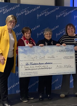 Des membres d'Accès Emploi remettent un chèque de 700 000$ à la vice-présidente de La Fondation franco-albertaine pour soutenir le développement philanthropique. C'est le plus important don jamais fait à la fondation communautaire francophone. Photo : Titti Freeman  