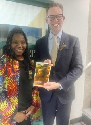 De la gauche vers la droite, Mireille Isidore, directrice et fondatrice de Kayanou, et Marlin Schmidt, député provincial d’Edmonton Gold-Bar, tenant un document sur les personnalités noires de l’Alberta produit par Kayanou.

 &mdash; Crédit : Florentine Tchokote