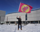 Amund Sjølie Sveen brandissant la bannière Pan-ArcticVision devant le centre culturel Katuaq à Nuuk lors du Pan-Arctic Vision 2024. — Crédit : Nordting