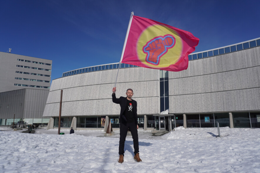 Amund Sjølie Sveen brandissant la bannière Pan-ArcticVision devant le centre culturel Katuaq à Nuuk lors du Pan-Arctic Vision 2024. — Crédit : Nordting