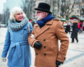 Joyful senior loving couple walking on square with enjoyment. They are talking and laughing  