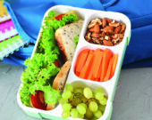 Lunch box with appetizing food and bag on table  