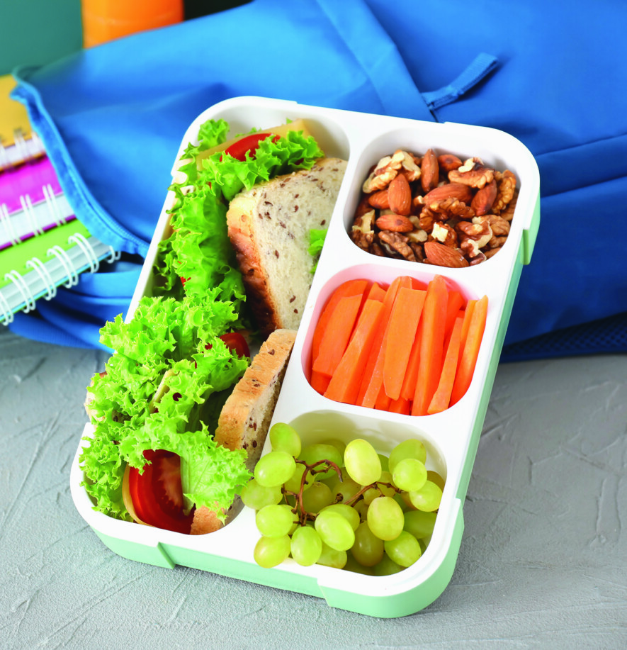 Lunch box with appetizing food and bag on table  