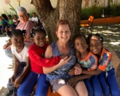 Lise est entourée d’enfants noirs lors de son voyage en République dominicaine, ce qui témoigne de son engagement pour apporter son soutien humanitaire. Engagée dans le bénévolat, elle partage son expérience marquante en République dominicaine ainsi que son regard sur l’égalité et la justice sociale.  &mdash; Photo de courtoisie