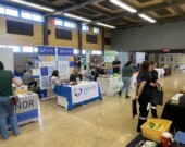 Des chercheurs d’emploi échangent avec des représentants d’entreprises locales lors de la foire d’emploi organisée au gymnase de l’Université de Hearst. &mdash; Photo : Ndery Dione