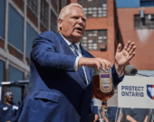 Le premier ministre de l'Ontario, Doug Ford, vide une bouteille de whisky Crown Royal lors d'une conférence de presse à Kitchener, en Ontario, le mardi 2 septembre 2025. &mdash; Photo : Sammy Kogan/Archives La Presse Canadienne