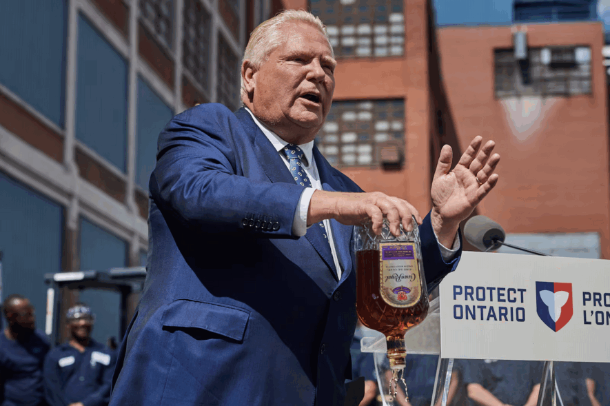 Le premier ministre de l'Ontario, Doug Ford, vide une bouteille de whisky Crown Royal lors d'une conférence de presse à Kitchener, en Ontario, le mardi 2 septembre 2025. &mdash; Photo : Sammy Kogan/Archives La Presse Canadienne