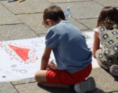 Des enfants dessinent sur une immense banderolle pour rendre hommage aux 18 500 enfants palestiniens morts de faim ou sous les bombes israéliennes.  &mdash; Photo : Inès Lombardo – Francopresse
