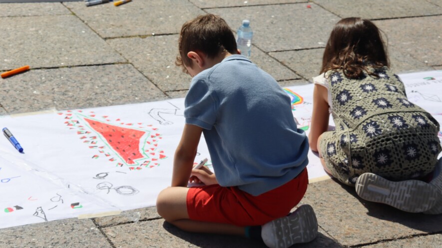 Des enfants dessinent sur une immense banderolle pour rendre hommage aux 18 500 enfants palestiniens morts de faim ou sous les bombes israéliennes.  &mdash; Photo : Inès Lombardo – Francopresse