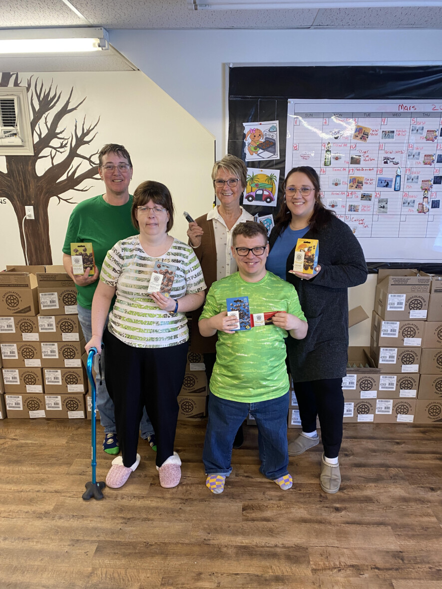 Chantal Goulet Dillon est entourée de deux membres du personnel de l’Intégration Communautaire et de deux participants derrière une commande de boîtes de chocolats qu’elle venait tout juste de recevoir. &mdash; Photo : Ndery Dione