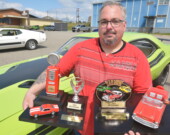 Yan Poirier prend la pose à côté de sa voiture de collection. Sur la couverture, le passionné d’automobiles exhibe fièrement les deux trophées qu’il a remportés lors de la deuxième édition du Motorama. — Éric Cyr (TDN)