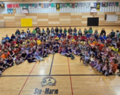 Les élèves et membres du personnel forment un arc-en-ciel pour célébrer la Journée mondiale de la sensibilisation à l’autisme.  — Photo : École Ste-Marie