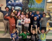 Des élèves dévoilent fièrement le nom de leur nouvelle mascotte, Koda le Jaglion. &mdash; Photo : École Notre-Dame de la Merci