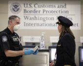 Aéroport international de Washington-Dulles, 18 mars 2020 : un agent du Service des douanes et de la protection des frontières des États-Unis accueille une pilote d’une ligne aérienne internationale &mdash; Glenn Fawcett ; source : https://www.flickr.com/photos/cbpphotos/49679050593/, image dans le domaine public.