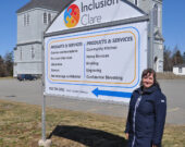 Carolyn Sloan, directrice de l’Inclusion Clare, en poste depuis quatre ans, devant l’affiche à la Pointe-de-l’Église.   &mdash; Richard Landry