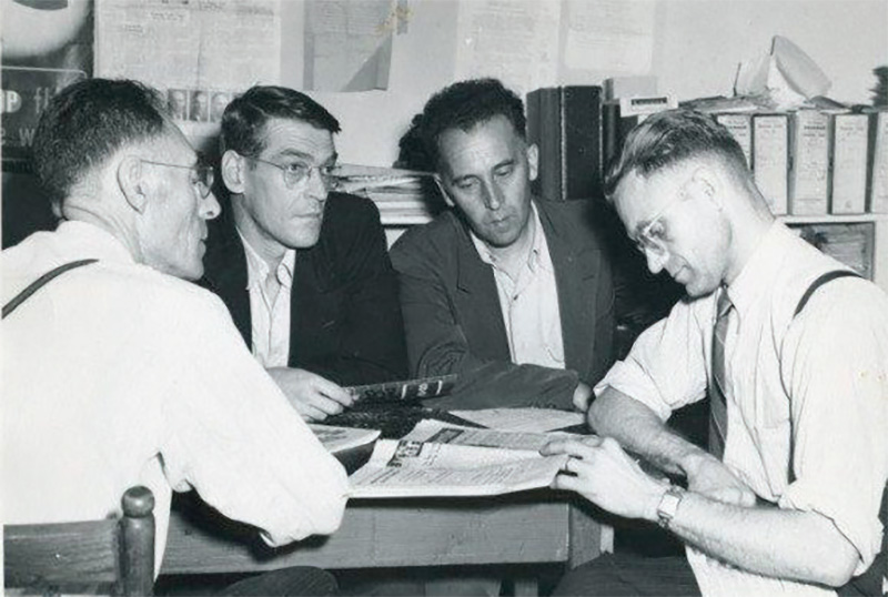 Prise en 1953, montrant une discussion sur les problèmes de fonctionnement de la Coopérative à Chéticamp. De gauche à droite : Geffrey LeFort, Dénis Aucoin (agent de terrain pour le département de vulgarisation) et gérant des coopératives de pêche de Grand-Étang et de Chéticamp, William LeFort (représentant agricole pour Inverness Nord) et Edmond Aucoin, gérant du magasin coopératif de Chéticamp) — Crédits : Archives