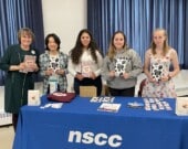 Quatre membres de Jeunes femmes en action avec leurs agendas à l’Assemblée générale de la FFANE au campus NSCC à Truro. De gauche à droite : Juliana Barnard, conseillère municipale à Truro, Shereen Sommerfeld, Alexis Ashe, Sophie LeBlanc et Jeane Le Provost.  &mdash; PHOTO - De gracieuseté - Juliana Barnard