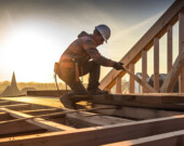 Un travailleur construisant une structure en bois d’une maison.
 &mdash; PHOTO : Michal - Adobe Stock