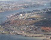 Vue aérienne d'Africville, montrant son emplacement sur le bassin de Bedford, avec l'extrémité nord d'Halifax et les Narrows en arrière-plan. &mdash; PHOTO: Bob Brooks - Nova Scotia Archives, 1989-468, vol. 16. 1965