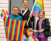 (de droite à gauche) Lydie Dugas-Hollie, Freya Nemeth, Celeste Huchet, et Rachelle Leblanc (en haut) posent avec leurs drapeaux de Fierté à l'extérieur du Seaside Bowling Lanes. 
 &mdash; PHOTO: Shannon Nickerson