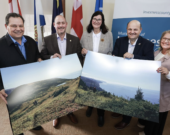 On aperçoit ici des représentants du Gouvernement de la Nouvelle-Écosse et de la Municipalité du comté d’Inverness tenant des photos de la région de Pollens Cove - Aspy Bay au nord du Cap-Breton. &mdash; Photo: Province de la Nouvelle-Écosse