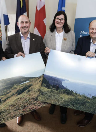 On aperçoit ici des représentants du Gouvernement de la Nouvelle-Écosse et de la Municipalité du comté d’Inverness tenant des photos de la région de Pollens Cove - Aspy Bay au nord du Cap-Breton. &mdash; Photo: Province de la Nouvelle-Écosse