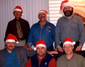 Noël 2003 à la Commission scolaire francophone du Yukon. De gauche à droite en commençant en arrière-plan : Edmond Ruest directeur général de la CSFY, et les commissaires Fernand Laforge, Luc Laferté, et au premier rang Richard Johnson, Chris Bookless et Marc Perreault. &mdash; Photo : Archives A.B.