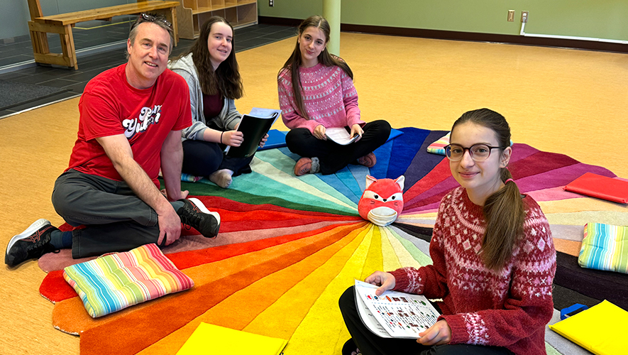 Iris, Camille et Chloé, avec Andrew Whittaker, responsable de la programmation pour la bibliothèque publique de Whitehorse.  &mdash; Photo : Sandra St-Laurent