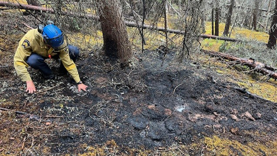 Un pompier vérifie la chaleur au sol sur l’incendie DA-002 dans la région de Dawson. L’incendie a été découvert, pris en charge et déclaré sous contrôle par les équipes le 16 juin.  &mdash; Photo : Gouvernement du Yukon