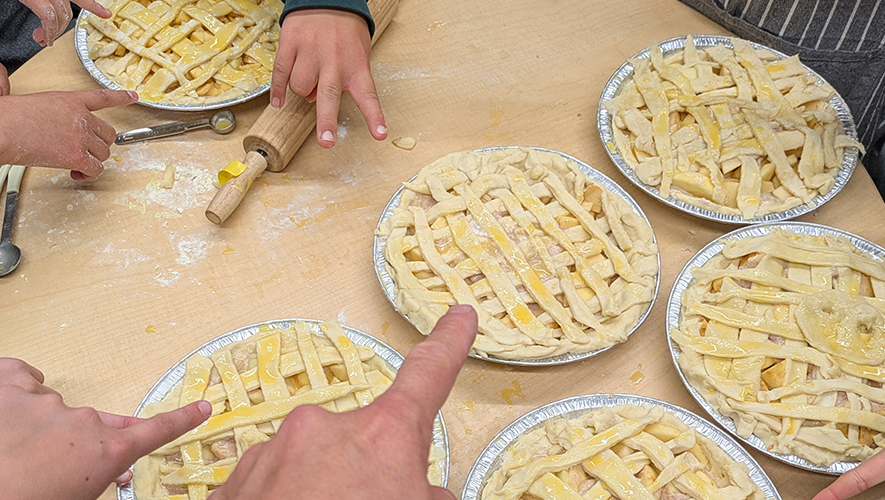 Autour de la table de cuisine du CSSC Mercier, les mains s’activent en français. Les jeunes participant·es pointent fièrement leurs tartes aux pommes prêtes à être enfournées. &mdash; Photo : Guillaume Weisser