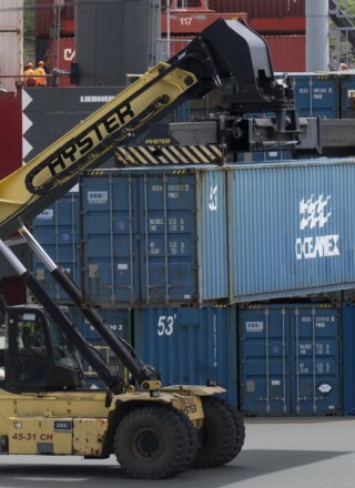 Un chariot élévateur déplace un conteneur dans un terminal de fret, à Saint-Jean, le dimanche 25 juin 2023. LA PRESSE CANADIENNE/Adrian Wyld &mdash; Adrian Wyld